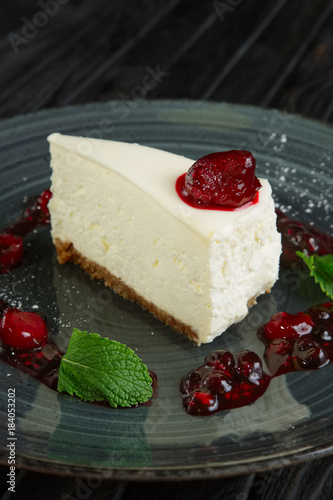 Closeup view of cheese cake decorated with cherry, strawberry and raspberry