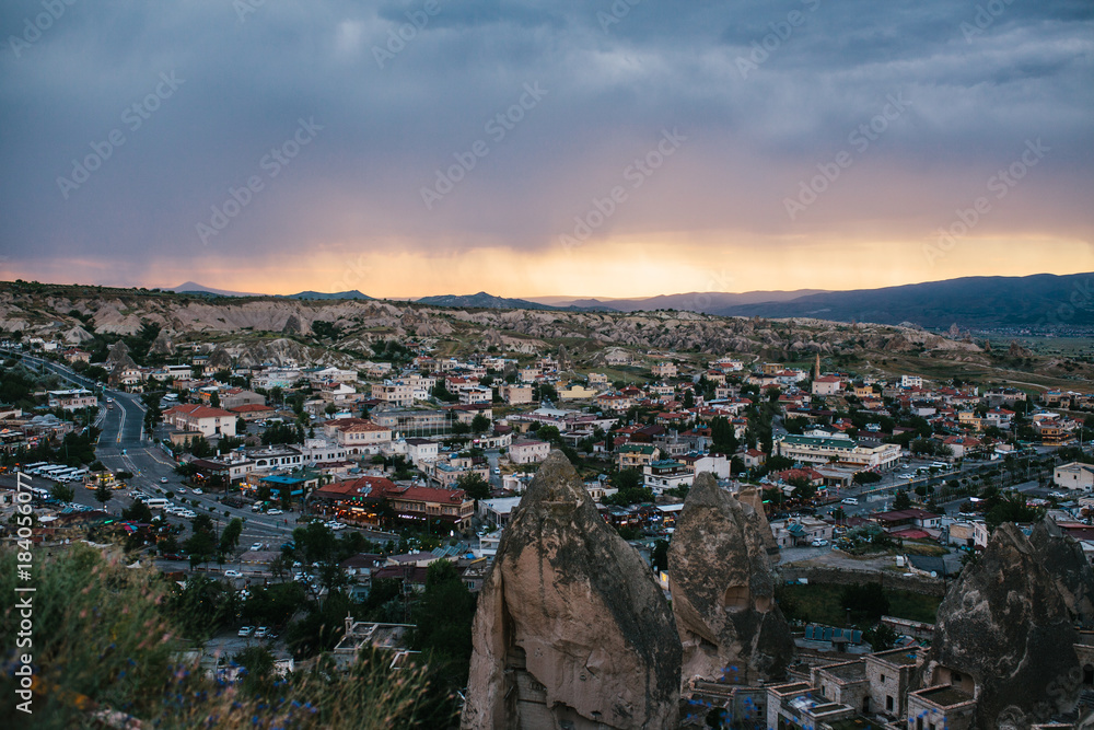 Top view. A small authentic city called Goreme in Cappadocia in Turkey in the evening. Dramatic night sky, sunset.