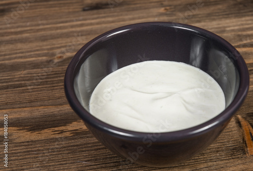 bowl of Mayonnaise sauce on a wooden background. with copy space