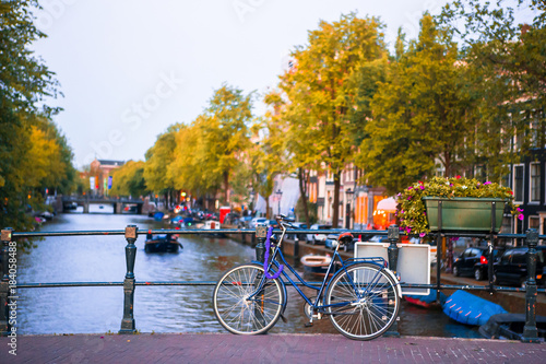 Bike on the bridge in Amsterdam, Netherlands. Beautiful view of canals in autumn