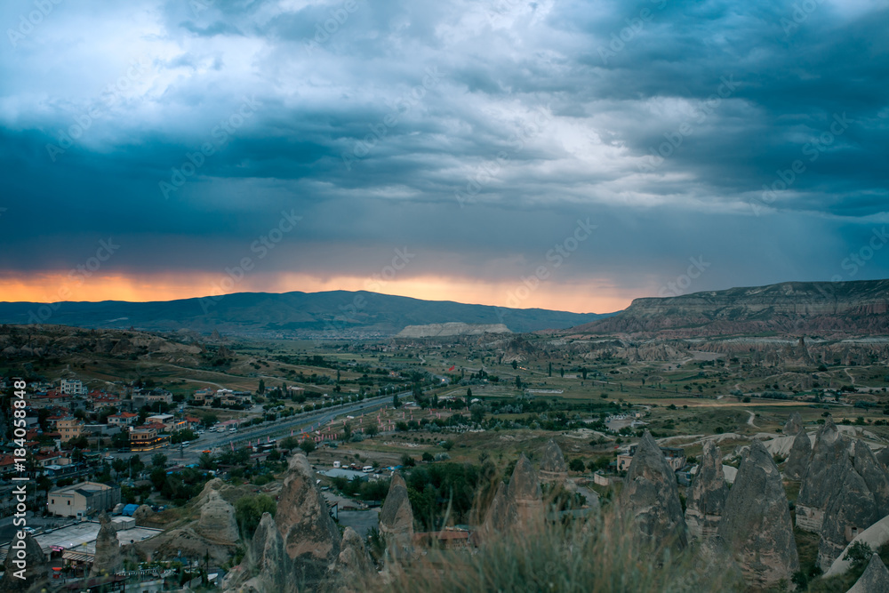 Top view. A small authentic city called Goreme in Cappadocia in Turkey in the evening. Dramatic night sky, sunset.