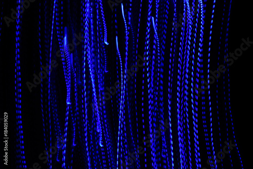 Abstract of bluecolored city lights beams in motion, Moving colorful lines or light painting LED building abstraction on busy city Light, chaos black background. Vertical desigh photo