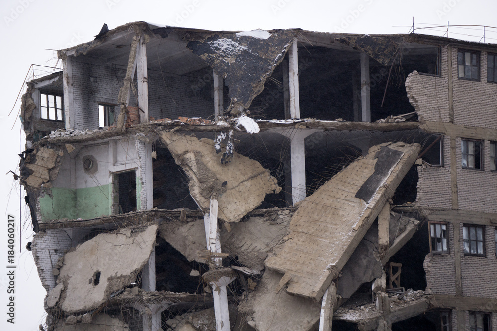 Room sections in the half-destroyed building. The collapse of the wall.