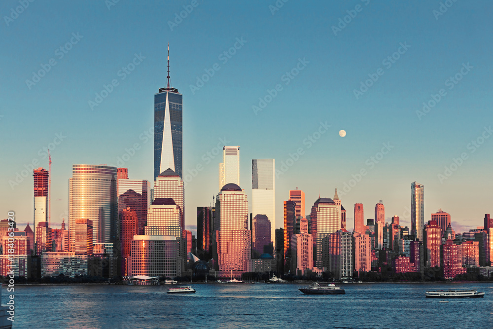 Fototapeta premium Lower Manhattan Skyline and moon rising at golden hour, NYC, USA