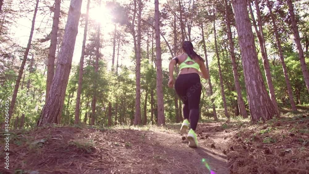 A girl jogging in the woods outdoors. Healthy lifestyle. A girl jogging in the woods outdoors. Healthy lifestyle.