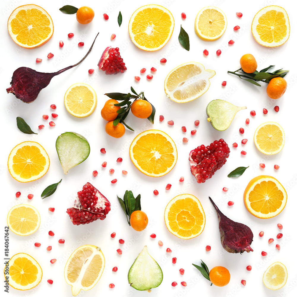 Naklejka Creative flat layout of fruit, top view. Sliced orange, lemon, beet, tangerine, green leaves isolated on white background. Food wallpaper, composition pattern of fresh fruits and vegetables.