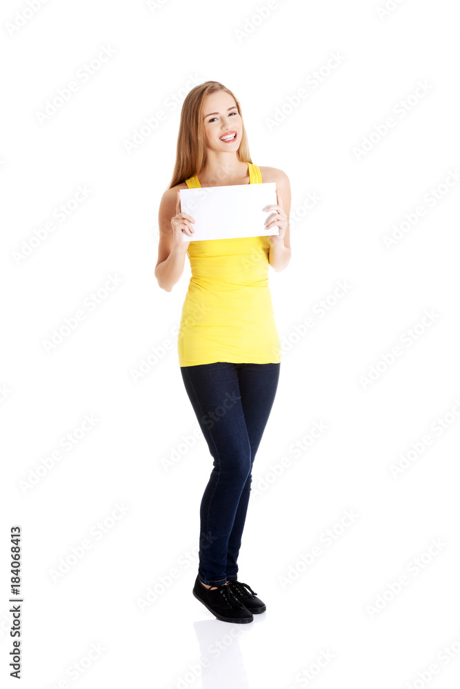 Attractive casual caucasian woman holds empty white piece of paper. Attractive casual caucasian woman holds empty white piece of paper.