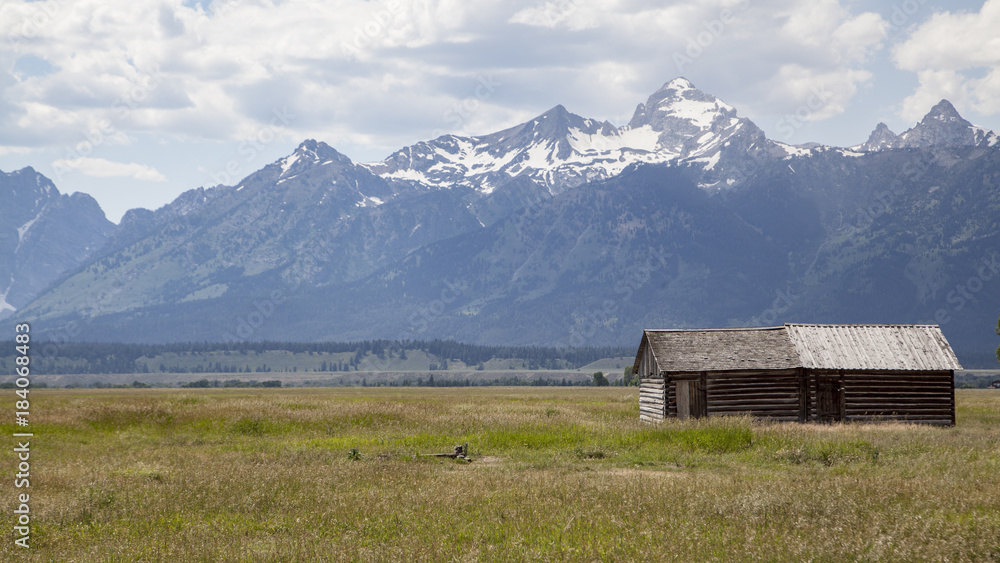 Moulton barn located in Mormon Row, Gros Ventre River Valley in Grand Teton National Park and active cloudy sky in background