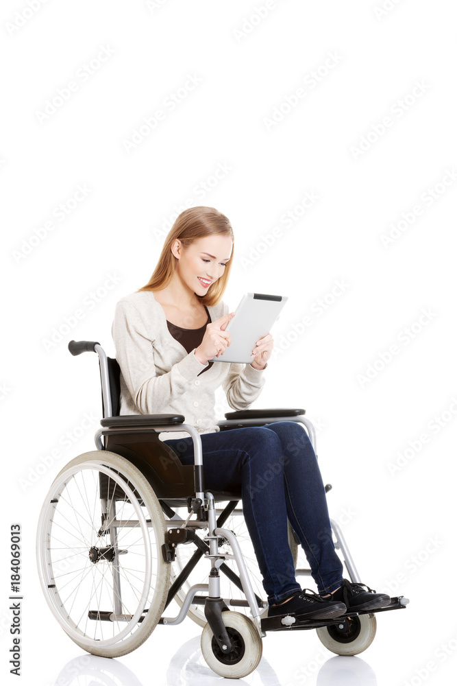 Beautiful casual woman sitting on w wheelchair with tablet. Beautiful casual woman sitting on w wheelchair with tablet.
