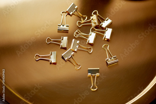 stationery gold pin on a gold background. Luxury office for business.