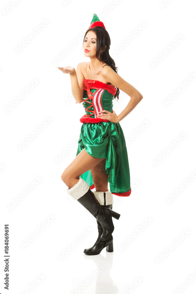 Full length woman wearing elf clothes blowing a kiss Full length woman wearing elf clothes blowing a kiss