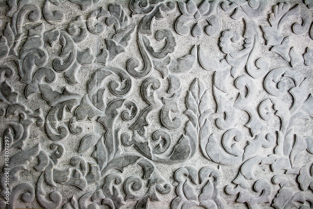 Stone carving emboss flower pattern,  craft work on black color of Granite stone. Concept image for interior design or architecture materials decoration.