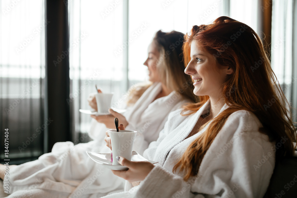 Obraz premium Women in bathrobes enjoying tea