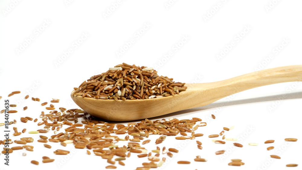 Brown rice in wooden spoon on isolated white background Brown rice in wooden spoon on isolated white background