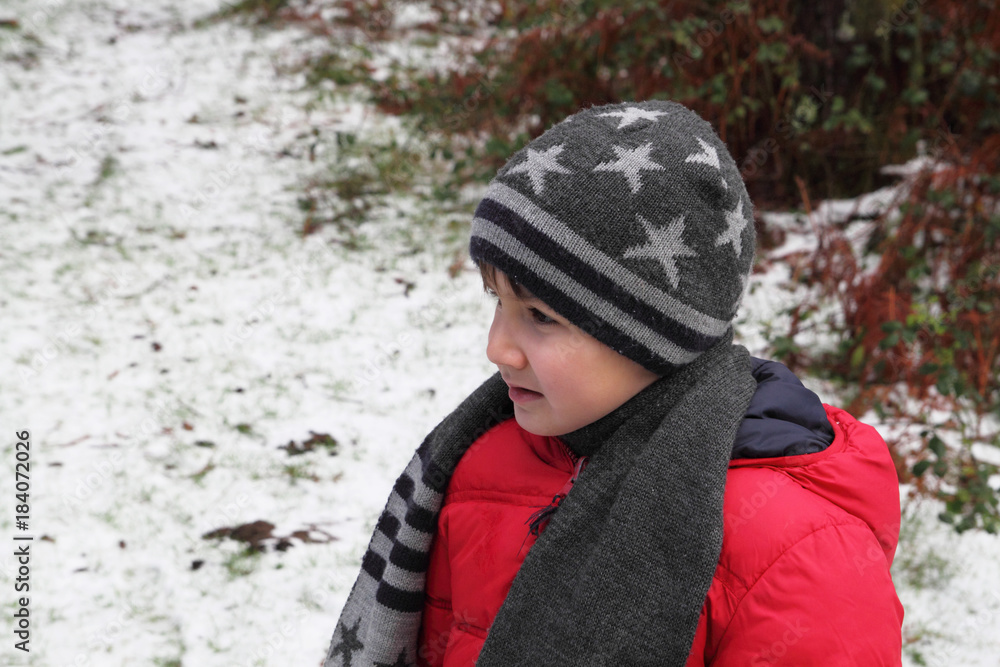 niño con gorro y bufanda en un bosque nevado niño con gorro y bufanda en un bosque nevado
