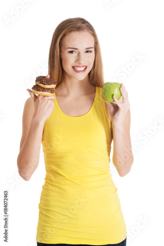Beautiful caucasian casual woman with doughnuts and apple.