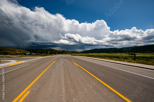 Empty open highway and stormy clouds in Wyoming