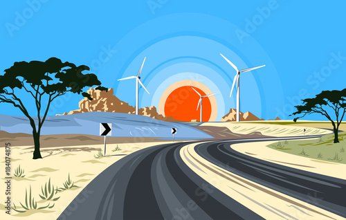 A modern highway on a deserted landscape, against the backdrop of mountains, dawn and windmills