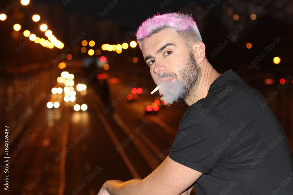 Fototapeta premium Alternative looking male smoking in the city