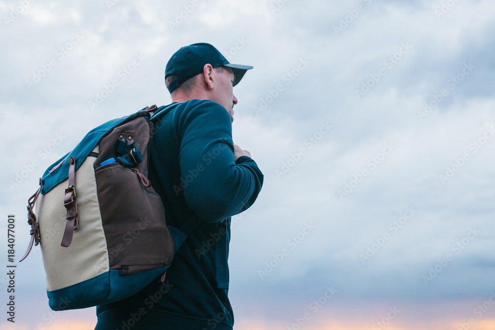 Man tourist with a backpack on the background of the setting sun. Evening. Sunset. Man tourist with a backpack on the background of the setting sun. Evening. Sunset.