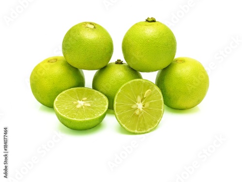 Five green limes (in pyramid stacking) and two splitted halves on white background. A kind of fruit used as an ingredient for cooking, especially in sour food. Scientific name - Citrus x aurantiifolia