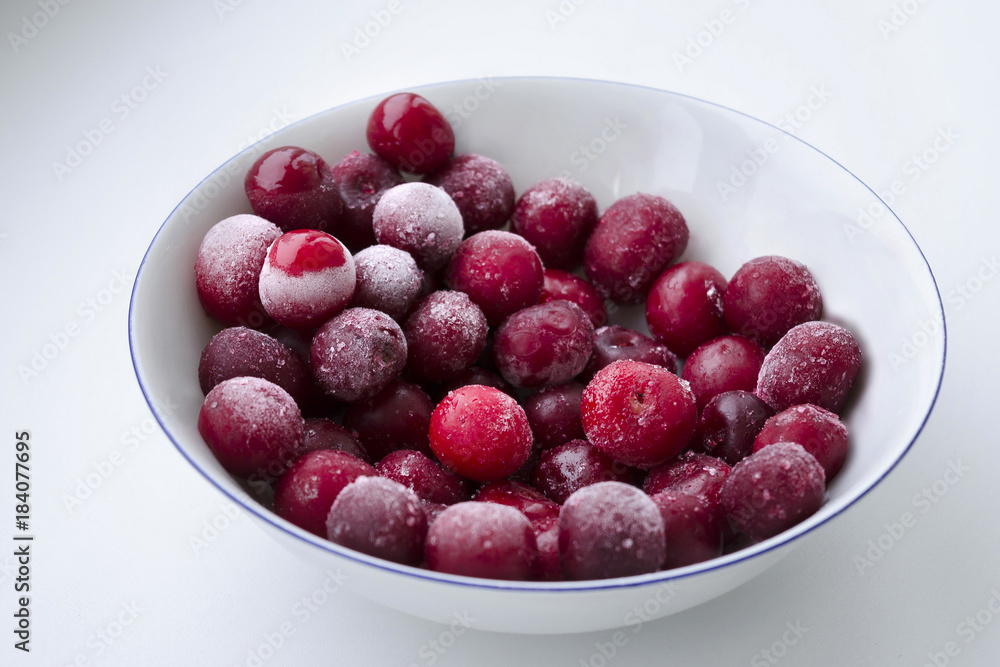 Frozen red cherries on a bright white background. Frozen red cherries on a bright white background.