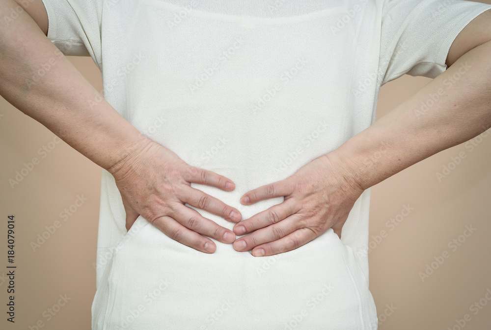Woman with backache holding her back Woman with backache holding her back