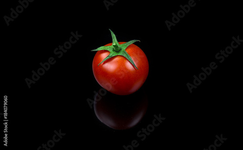 Fresh cherry tomato single on black background