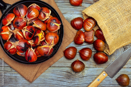 Chestnuts in a pan on wooden background
