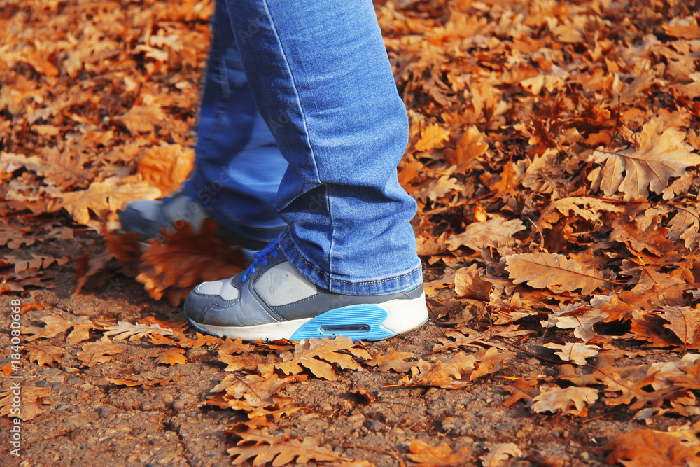 Young woman walking in autumn park close up