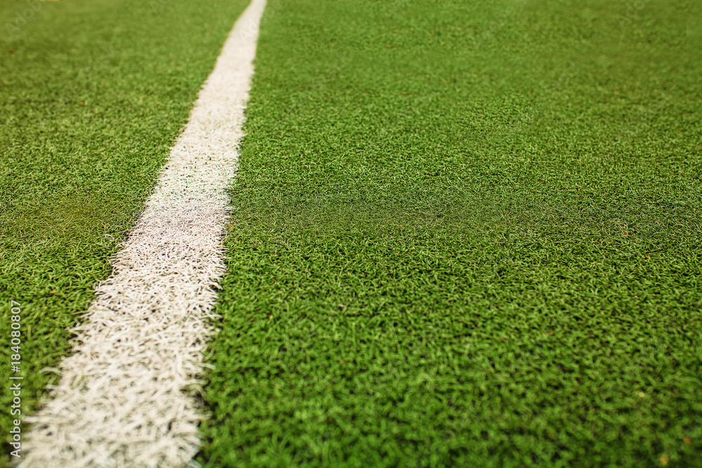 Green artificial grass soccer field. The white line on a Green football field background. Green artificial grass soccer field. The white line on a Green football field background.