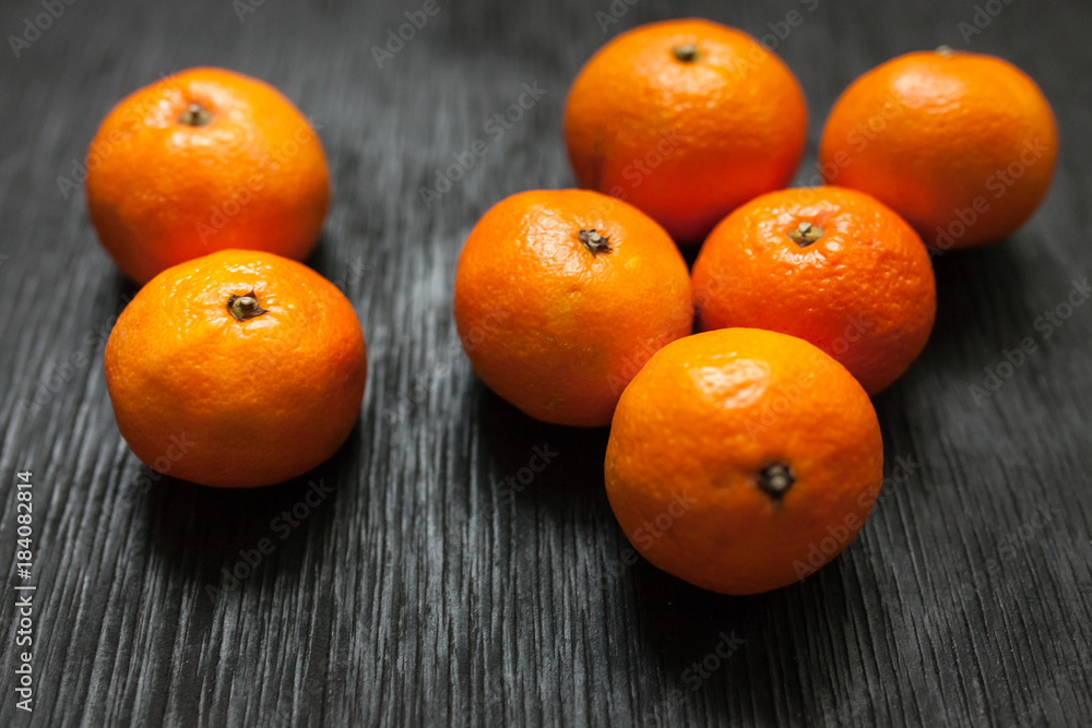 Tangerines on a black background. Lots of fresh fruit - mandarins. Tangerines on a black background. Lots of fresh fruit - mandarins.
