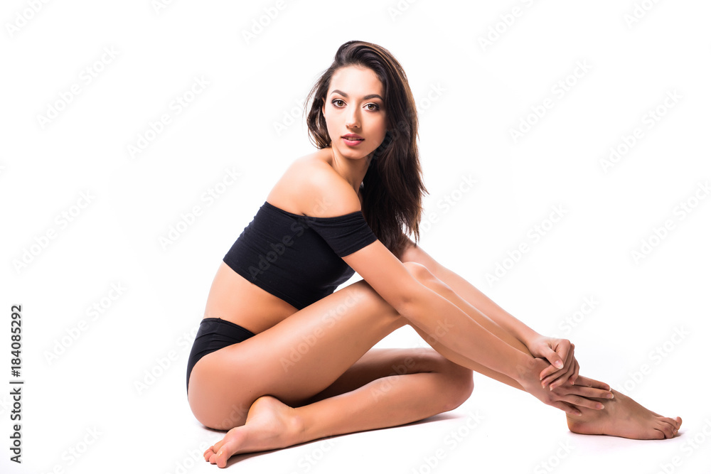 Fit and sporty girl in black underwear on the floor. Beautiful and healthy woman posing over isolated white background. Sport, fitness, diet, weight loss and healthcare concept. Fit and sporty girl in black underwear on the floor. Beautiful and healthy woman posing over isolated white background. Sport, fitness, diet, weight loss and healthcare concept.
