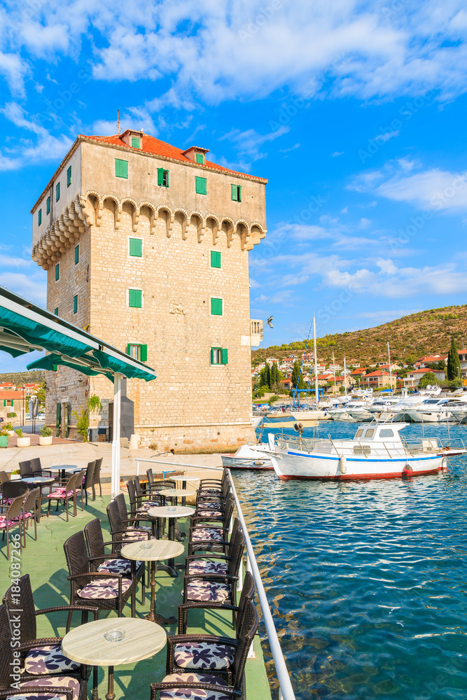 Old historic tower and fishing boat in Marina Agana port, Dalmatia, Croatia