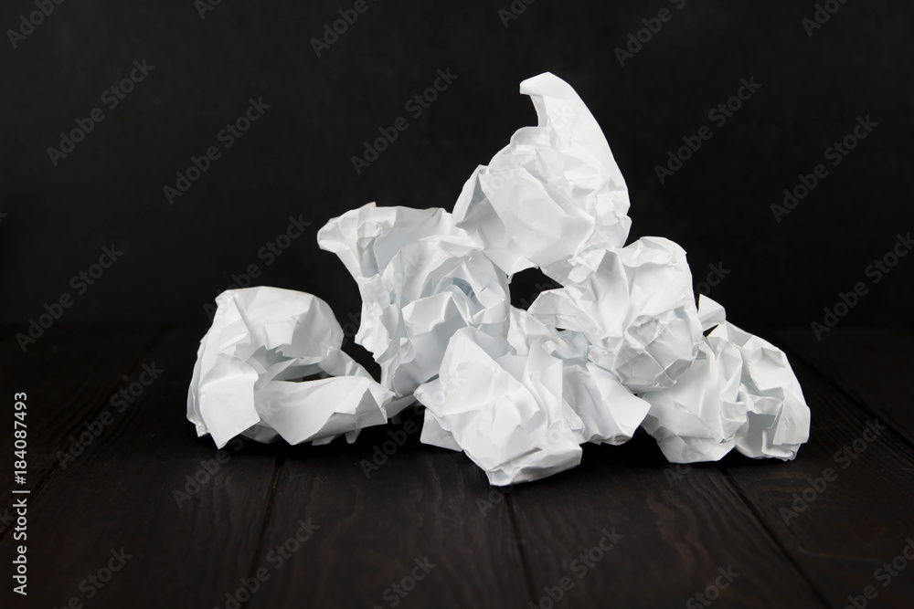 White note pad on a wooden table. Writing concept - crumpled up paper wads with Notepad White note pad on a wooden table. Writing concept - crumpled up paper wads with Notepad