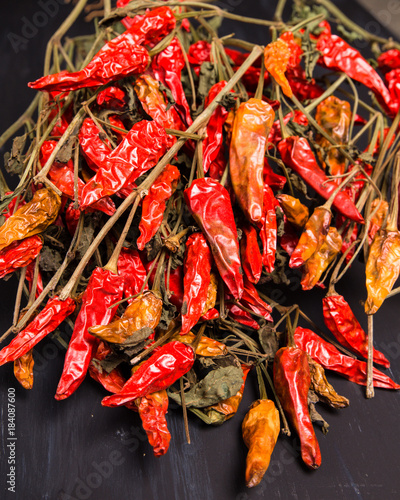 Spicy dried red chili peppers on wood surface