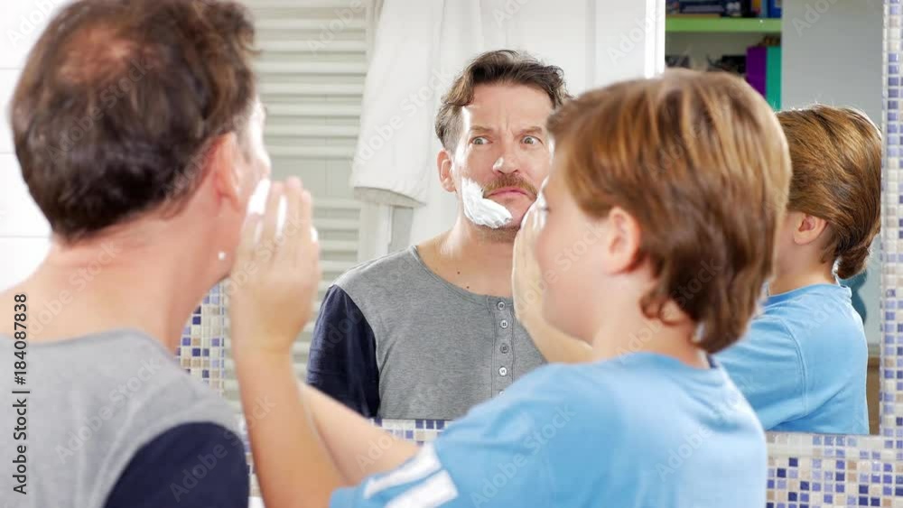 Father letting son putting shaving cream on his face funny Father letting son putting shaving cream on his face funny