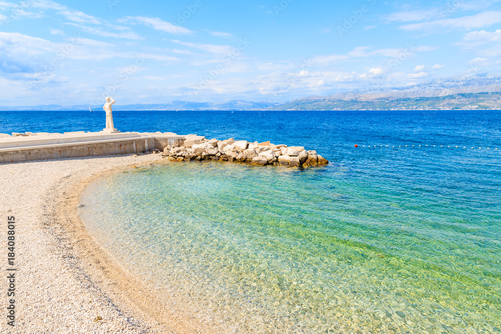 Fototapeta premium View of beach with turquoise sea water in Postira village, Brac island, Croatia