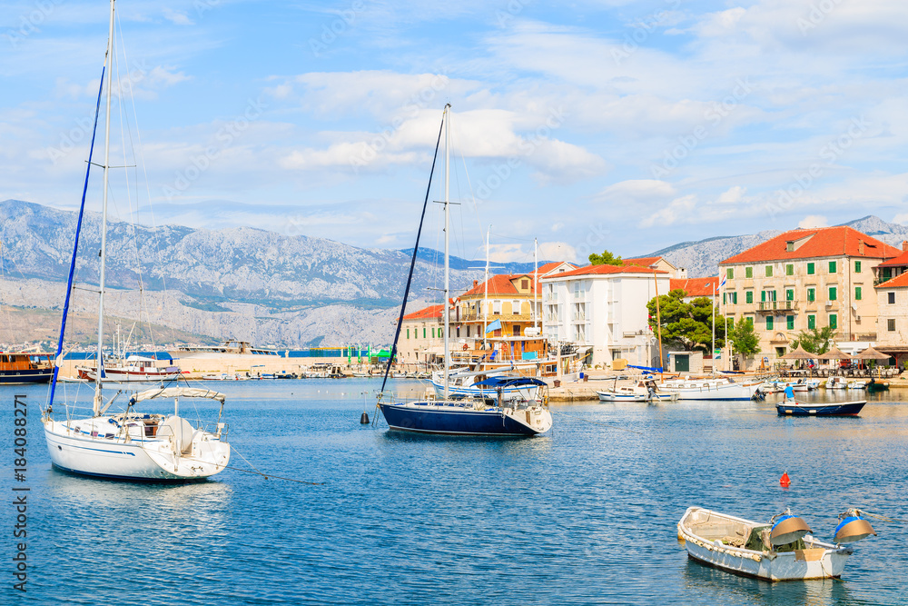 Fishing and sailing boats in Postira village with beautiful port, Brac island, Croatia.