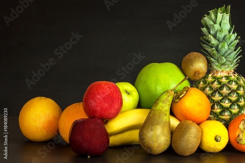 Different fruits on a black kitchen table. Food for athletes. Vitamins against colds and flu.