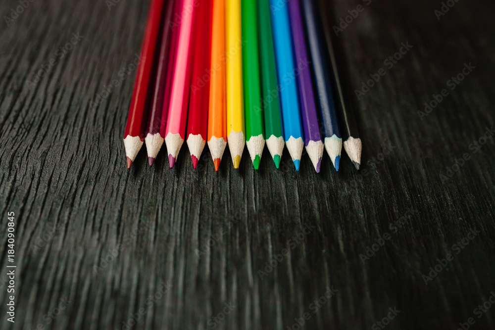Many colored pencils on a black background. New pencils Many colored pencils on a black background. New pencils