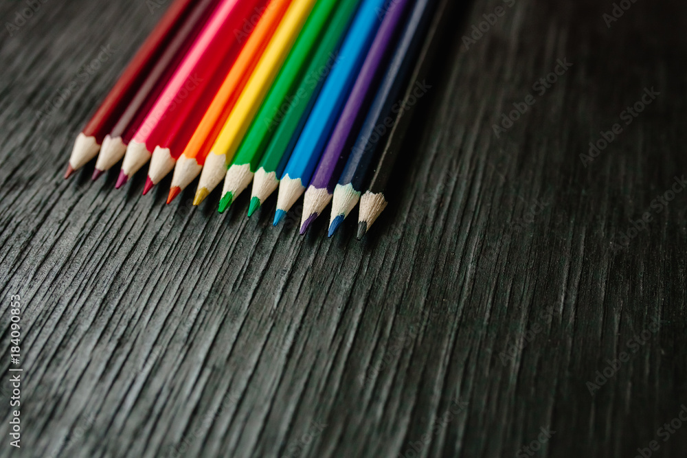 Many colored pencils on a black background. New pencils Many colored pencils on a black background. New pencils