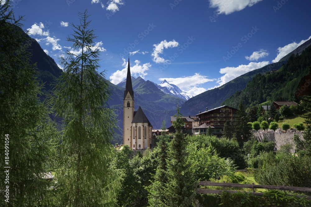 Beautiful landscape view to St Vincent Church and Grossglockner massif in Heiligenblut village in Alps mountains in Carinthia region, Austria. 