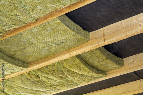 Thermal insulation mineral rock wool installation at the new building attic ceiling photo