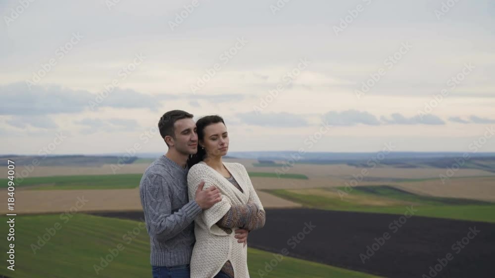 Cute lovely couple stand in embraces on the precipice of a rock. 4K Cute lovely couple stand in embraces on the precipice of a rock. 4K