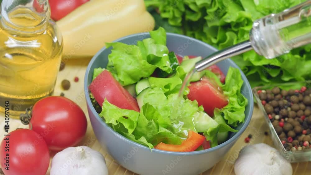 Pouring oil in salad from glass bottle with dispenser Pouring oil in salad from glass bottle with dispenser