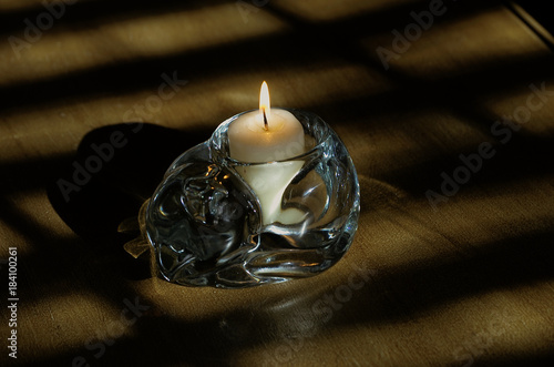 Glass cat candle holder on table with flame