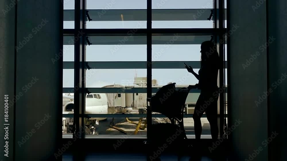 Silhouette of woman passing by with a luggage in airport.