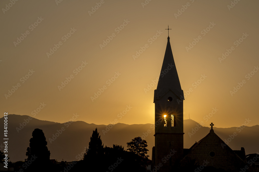 Sunrise behind bell tower of monastery of St. Martin in Sumartin on island Brac in Croatia