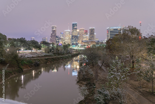 Unusual snowfall along Bayou River bank with downtown Houston, Texas, USA skylines city lights reflection at sunrise/twilight. Snow is extremely rarely in Houston and happen only 35 times since 1895